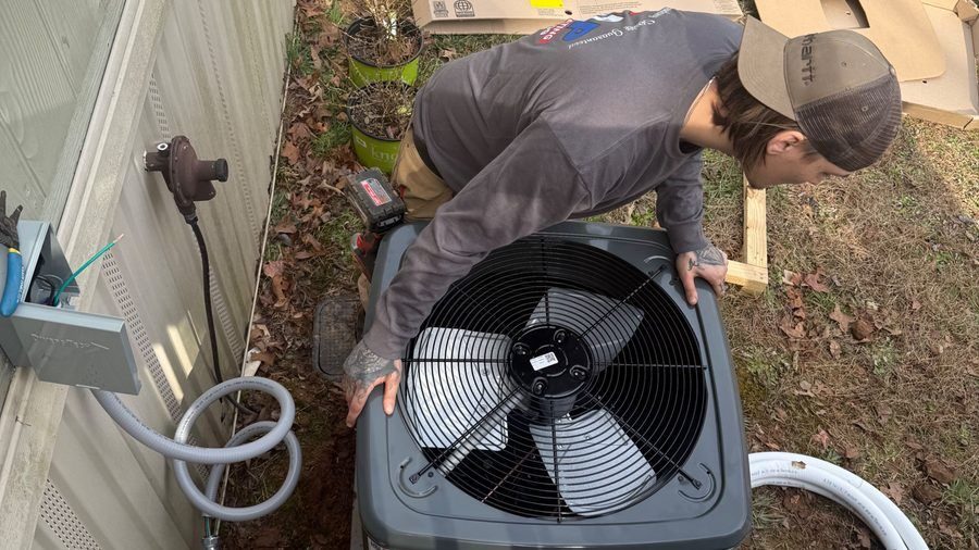HVAC tech installing air conditioning unit.