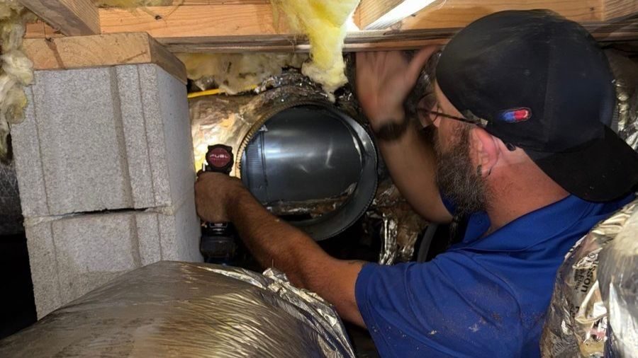 Tech repairing and inspecting ductwork.